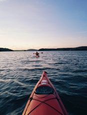 red canoe in body of water during daytime