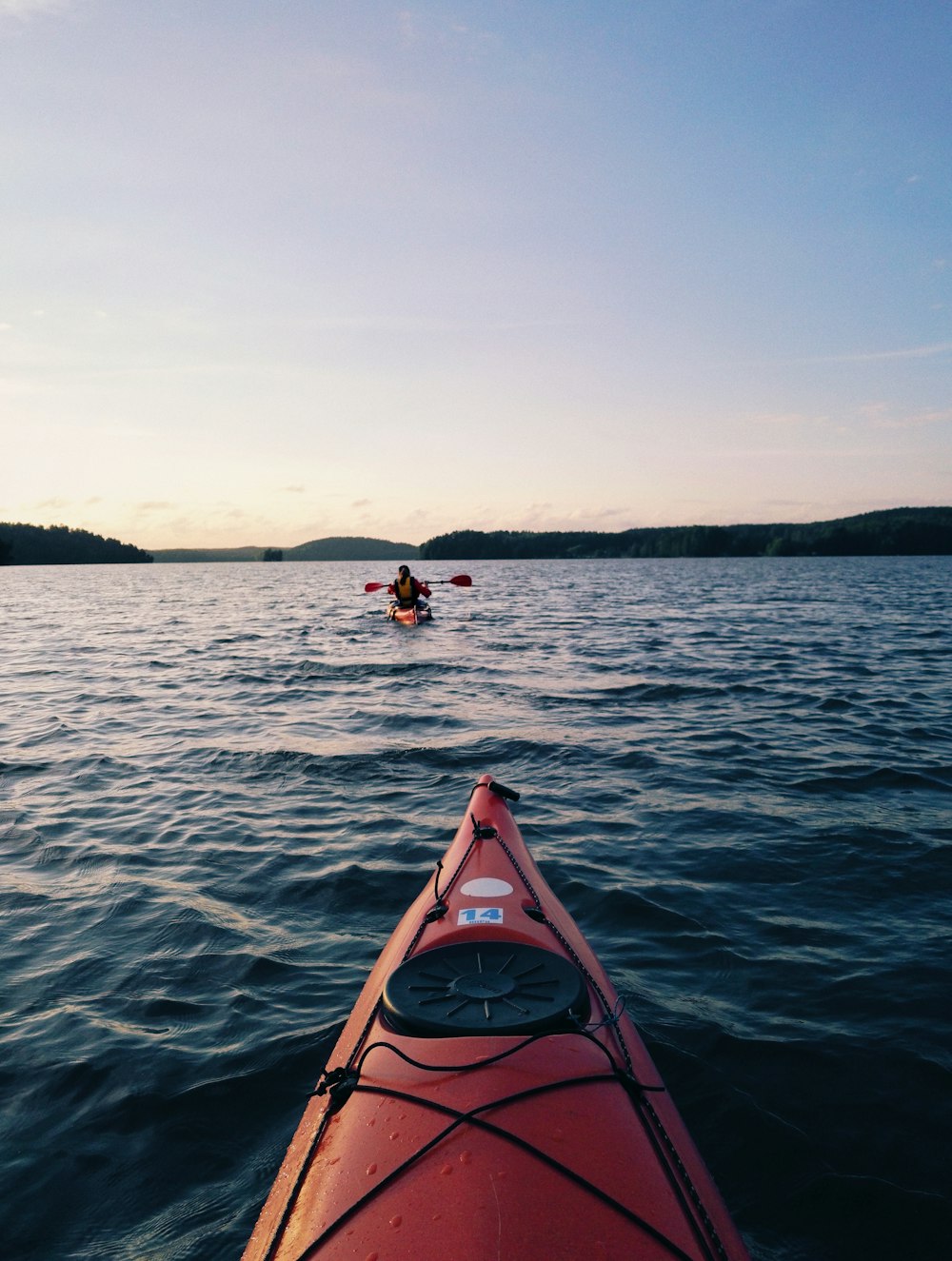 canoa vermelha no corpo de água durante o dia