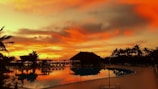 A vibrant sunset over a tropical beach resort.