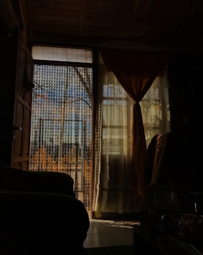 Blackout room divider curtains hanging in a softly lit room creating a private nook.