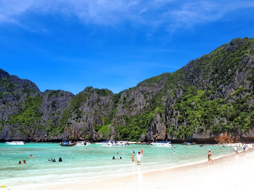 people bathing in white sand beach during daytime