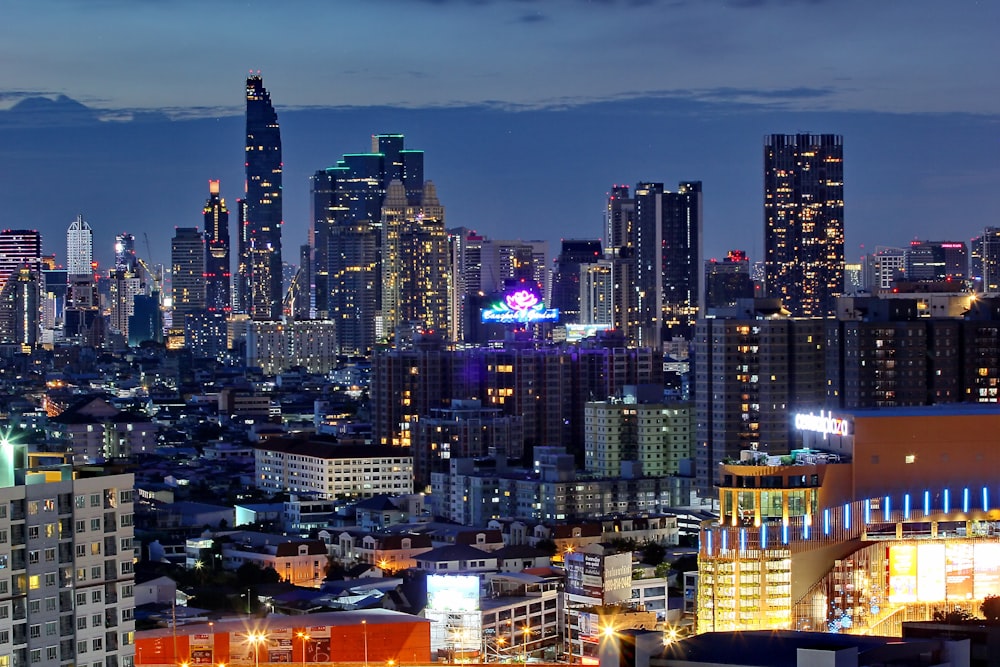 aerial photography of city with high-rise buildings viewing mountain during night time