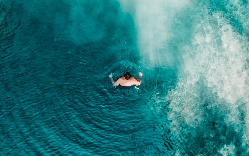 a man swimming in the middle of a large body of water