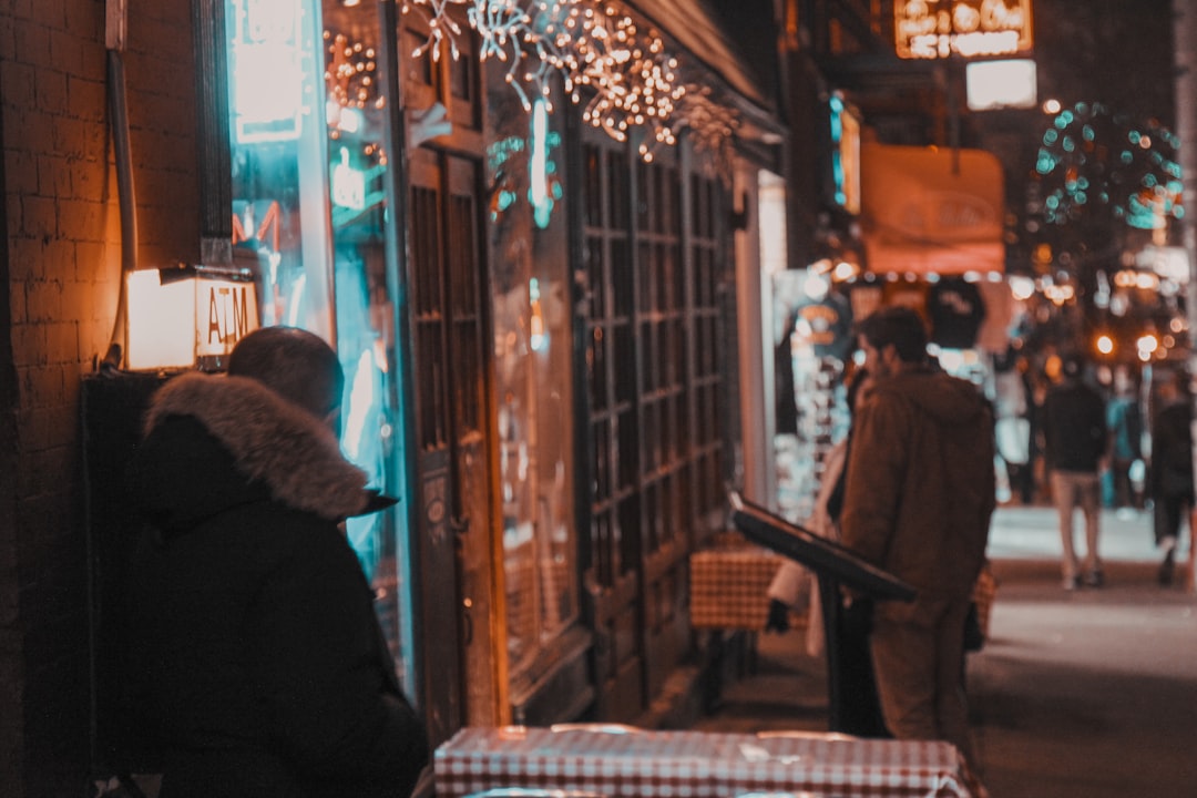 a couple of people walking down a street at night,