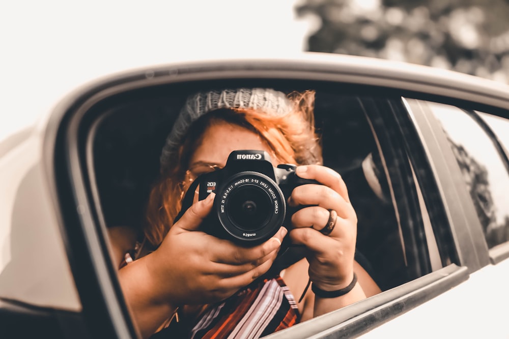Frau sitzt im Auto, während sie fotografiert