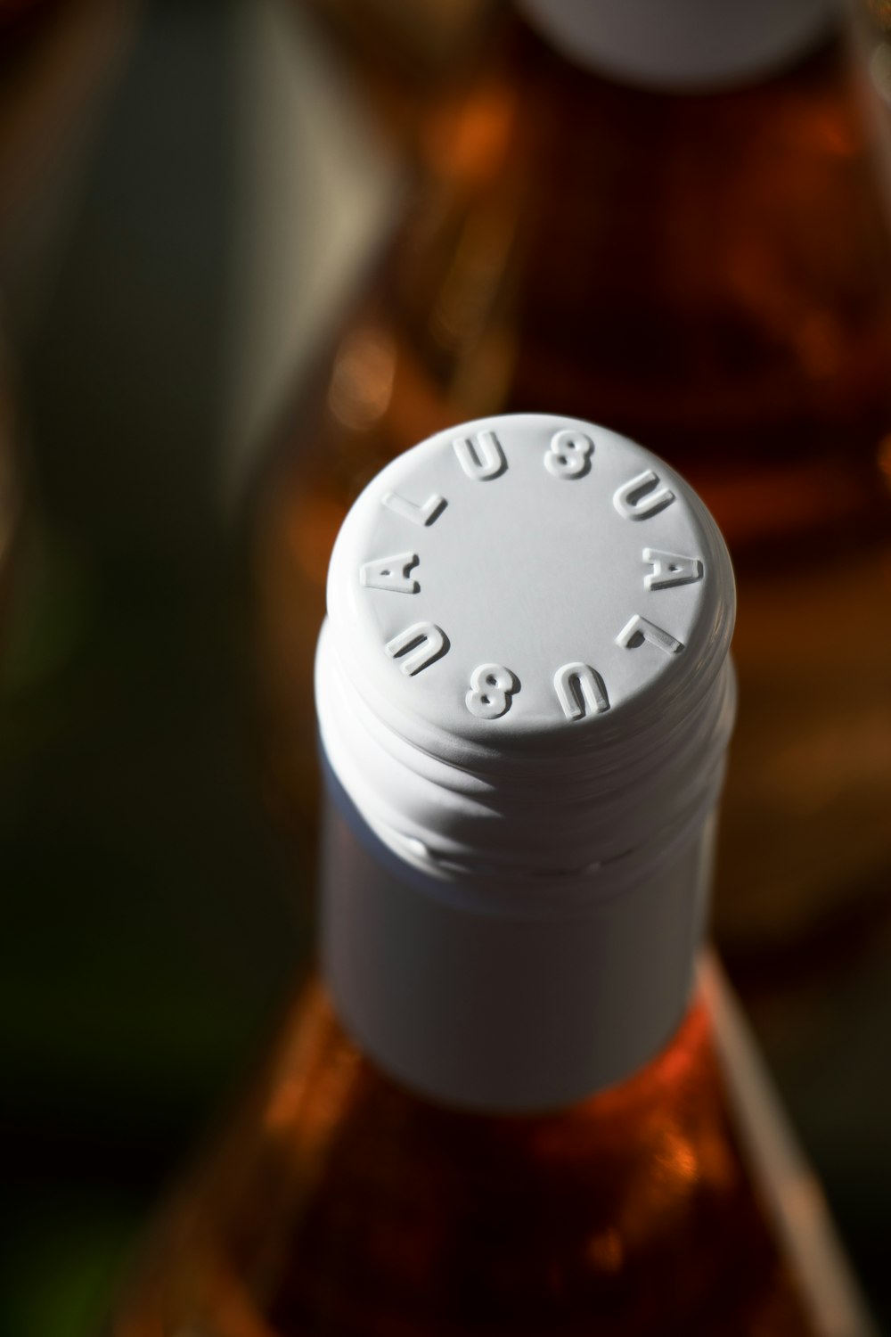 a close up of a bottle with a white cap