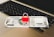 An Indian 500 rupee note is placed on a laptop keyboard with a red padlock sitting on top of the note.