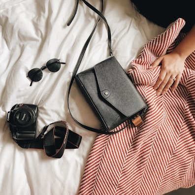 black Canon DSLR camera and black sunglasses