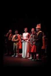 A vibrant ceremony stage with award winners holding trophies under bright lights.