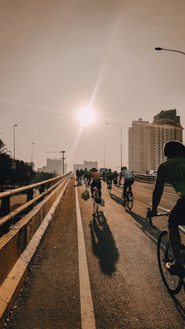 A group of cyclists riding together on a scenic country road at dawn.