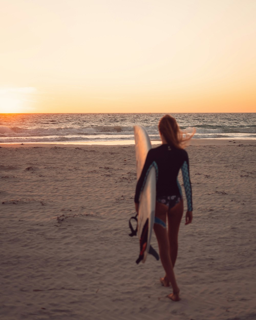 woman holding white surfboard