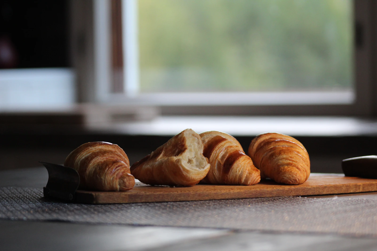 Croissants sobre a mesa iluminados por luz natural