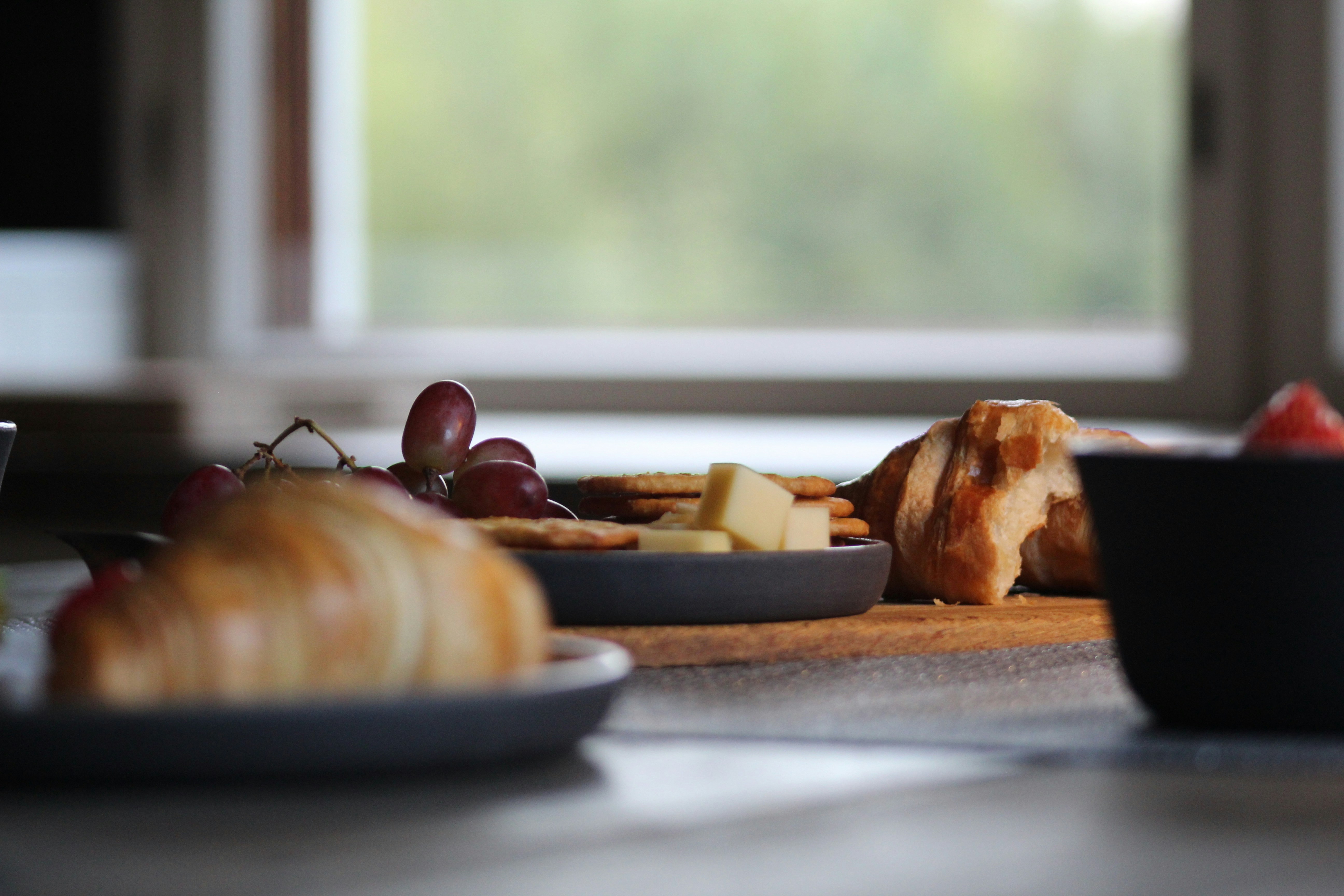 Assortment of grain-free dog treats styled on wooden table with fresh turkey and bacon ingredients