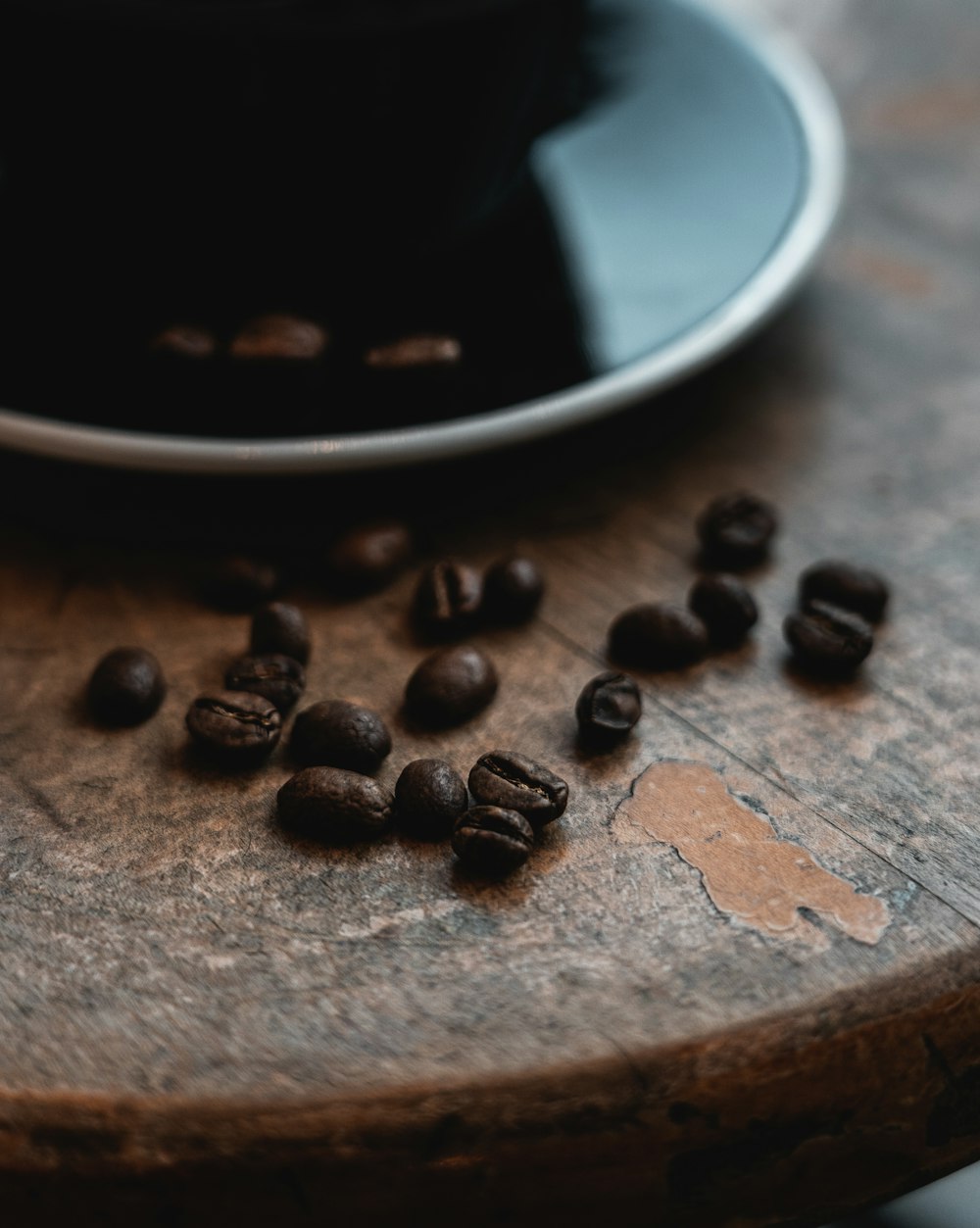 a wooden table topped with a plate of coffee beans