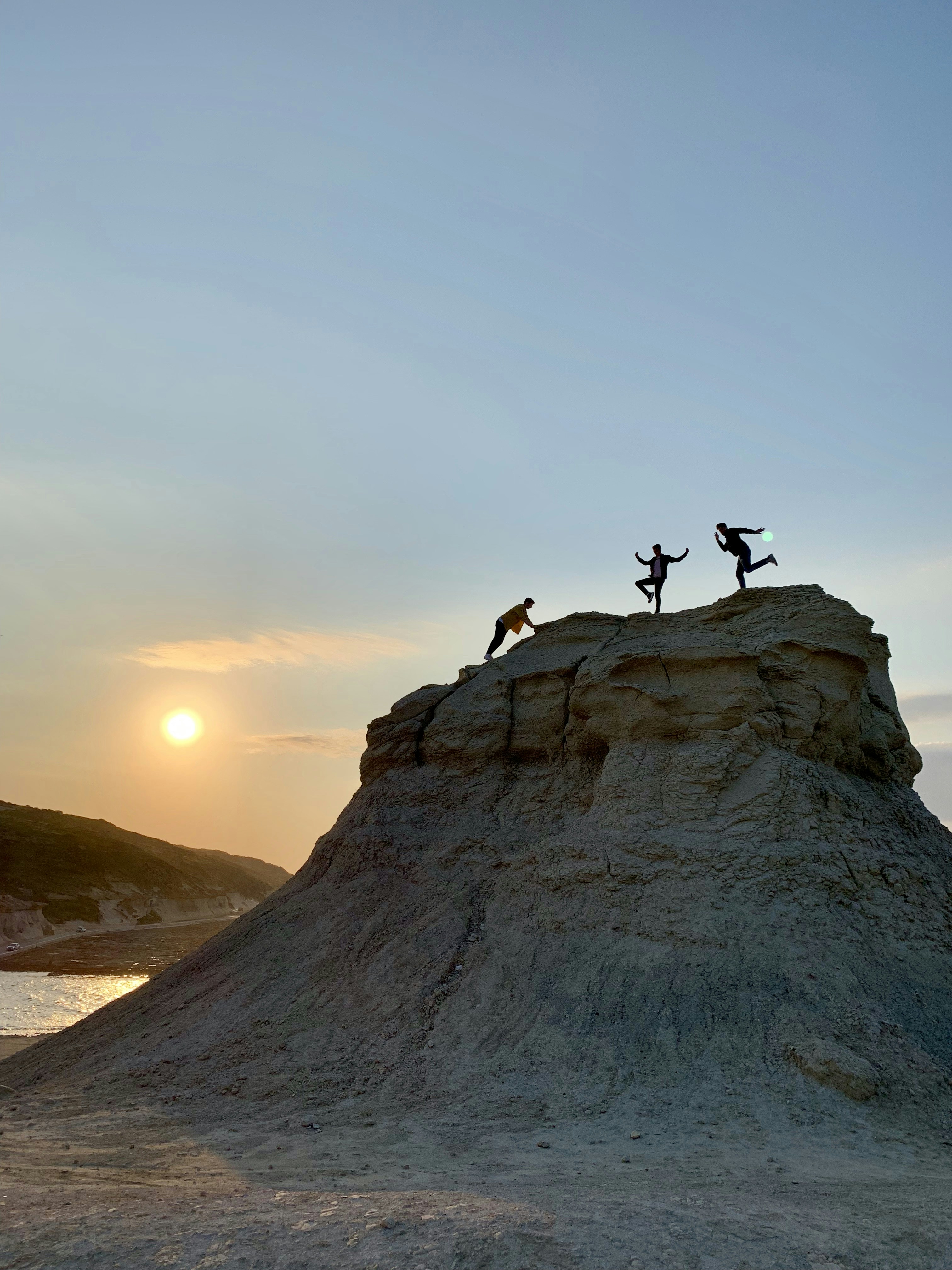 Three people on top of Xwejni Rock.