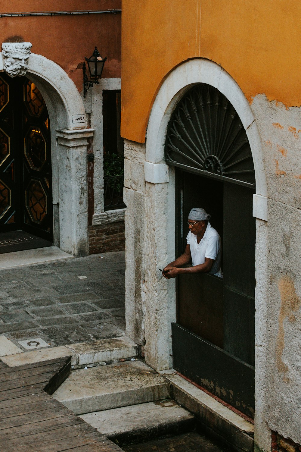 man in white polo shirt in front of gate