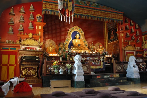 Close-up of intricate Buddhist statues and offerings arranged carefully on an altar.