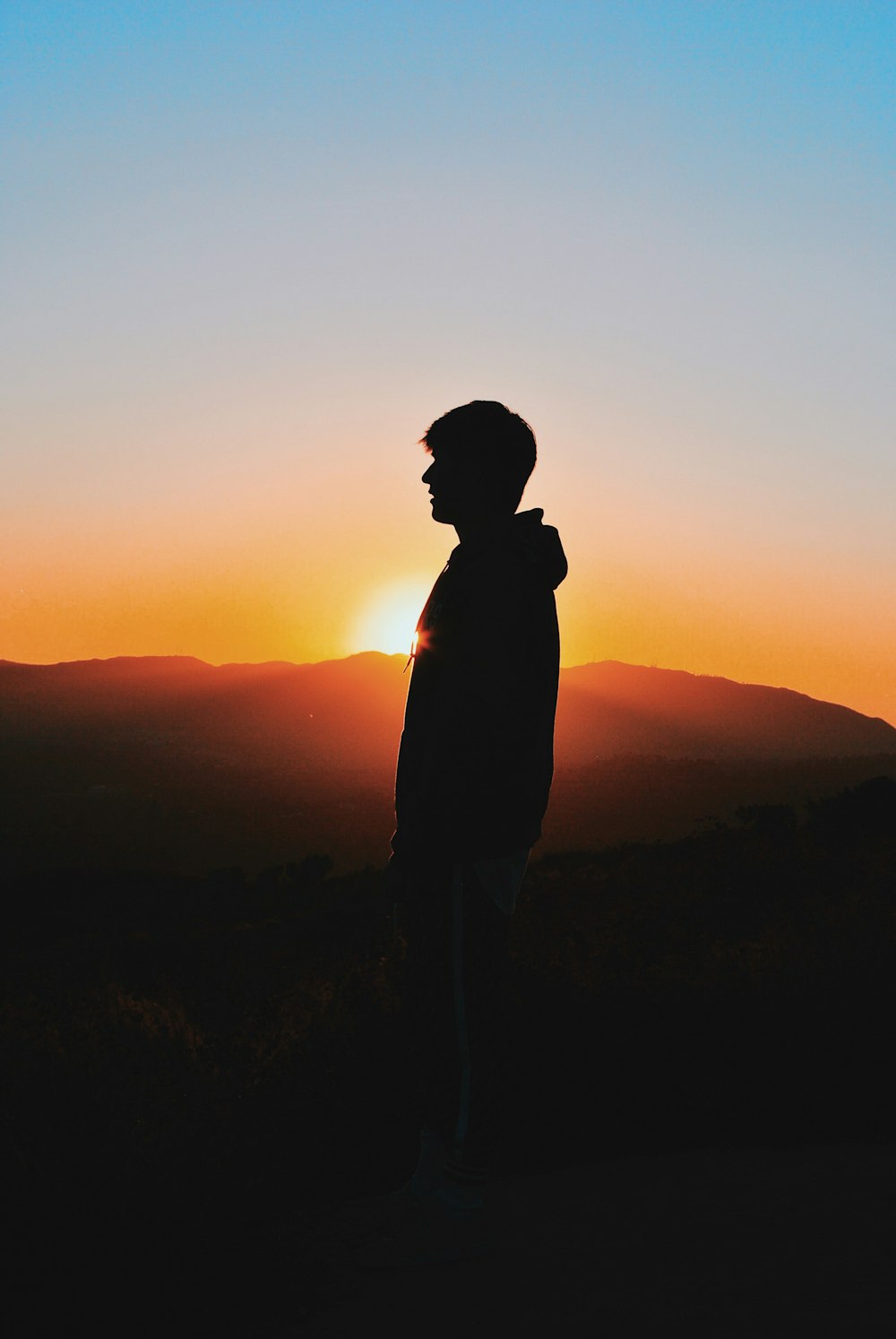 man wearing hoodie during golden hour