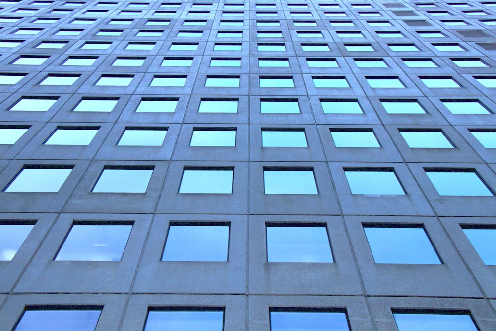 low-angle photography of blue highrise glass building