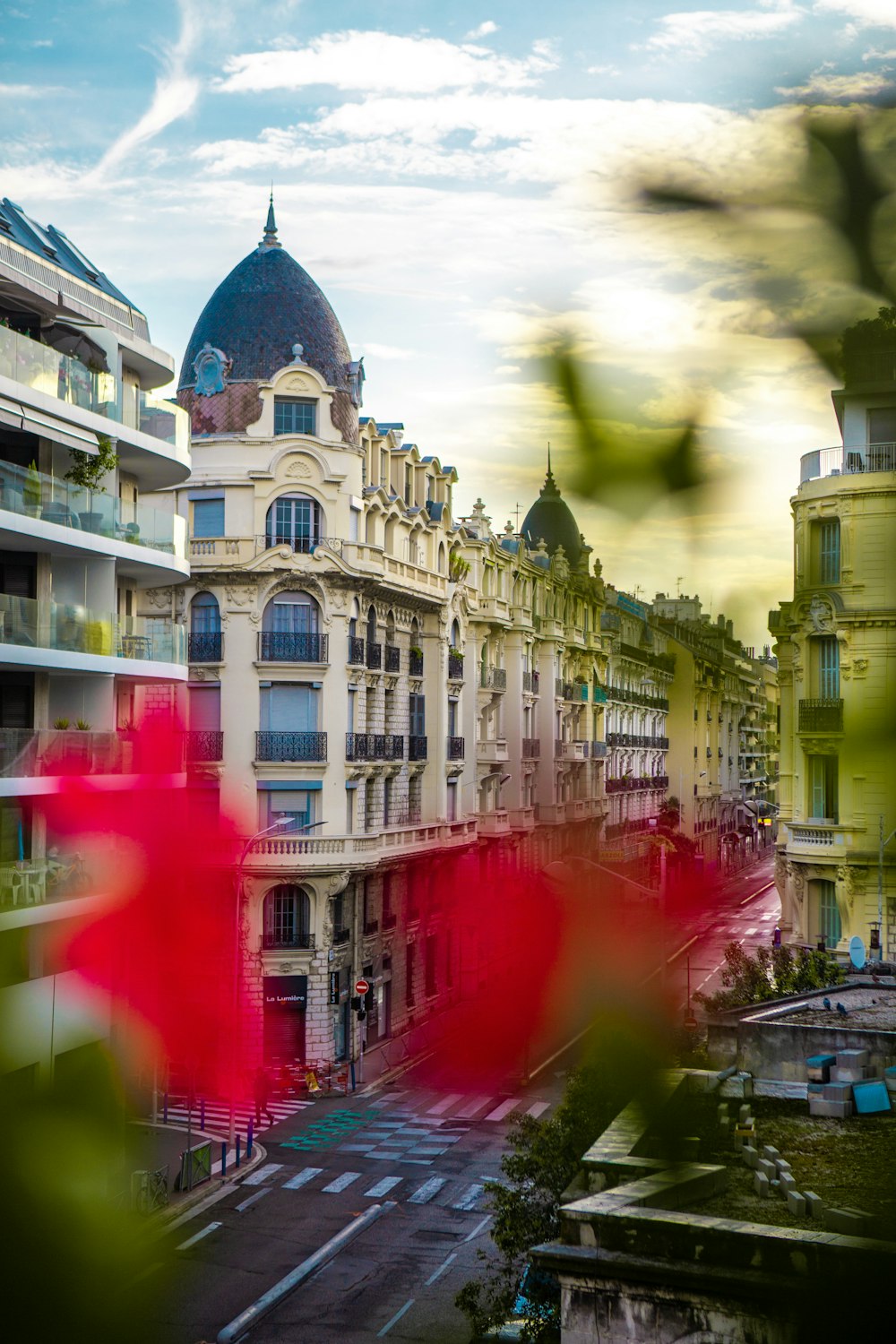 Una foto sfocata di un edificio con un fiore rosso in primo piano