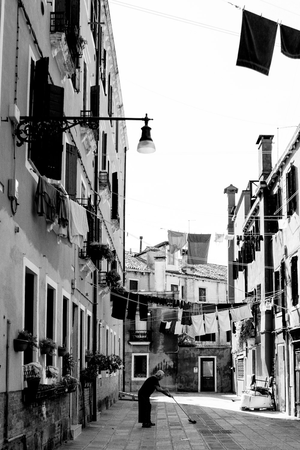 grayscale photography of person on pathway near buildings