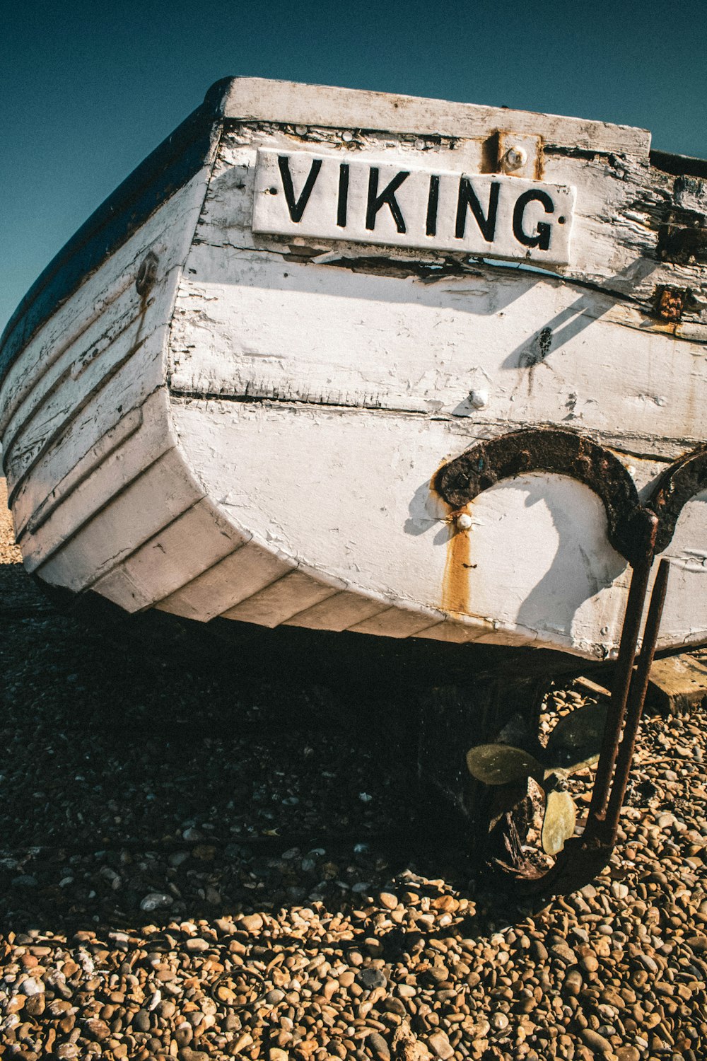 white wooden boat on black sand