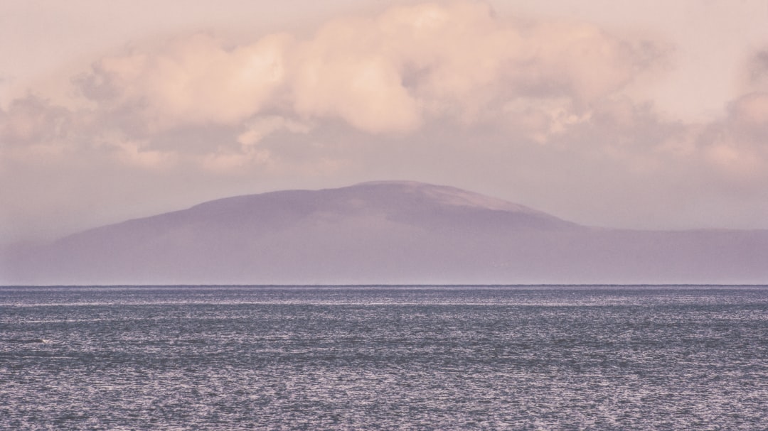 body of water near mountain at golden hour