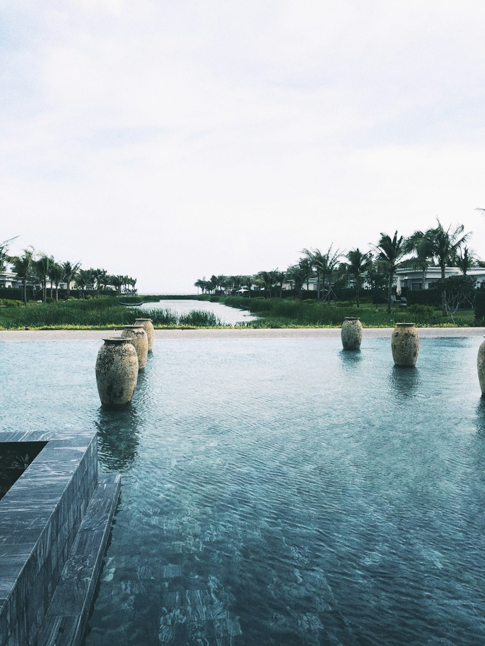 five white vases on blue water