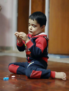 Close-up of a toddler happily exploring colorful toys in a cozy home setting.