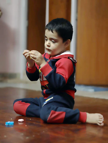 Close-up of a child's hands exploring a wooden Pikler triangle in a bright, calm room.