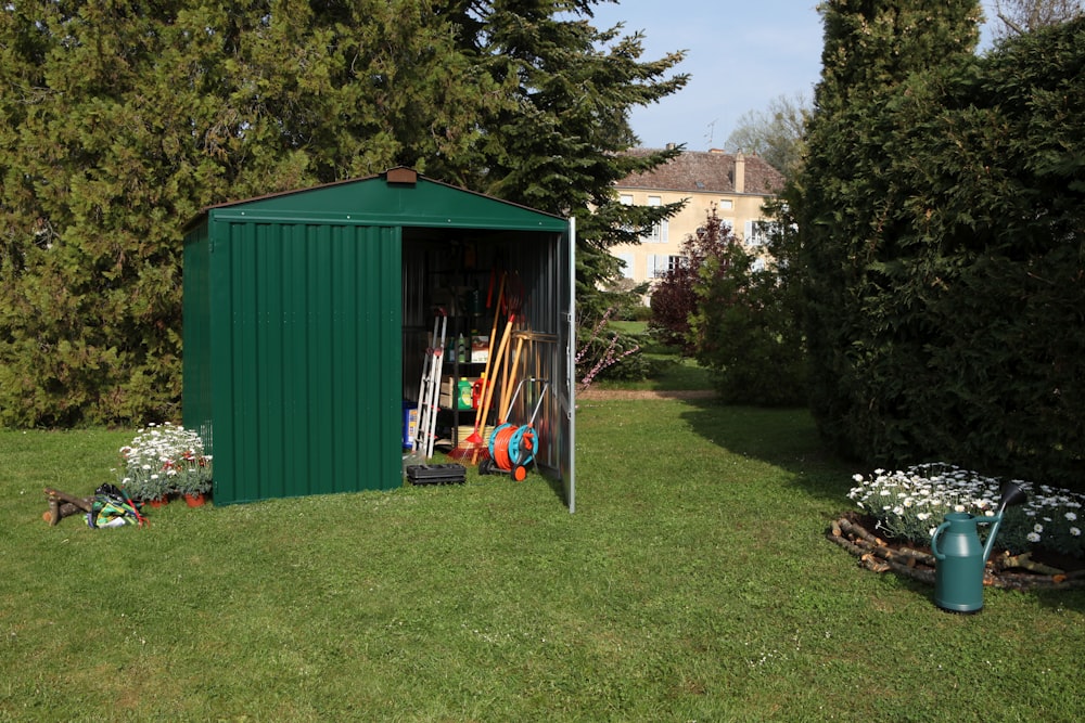 half opened green shed on grass near trees