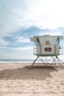 a lifeguard tower on a beach with a sky background