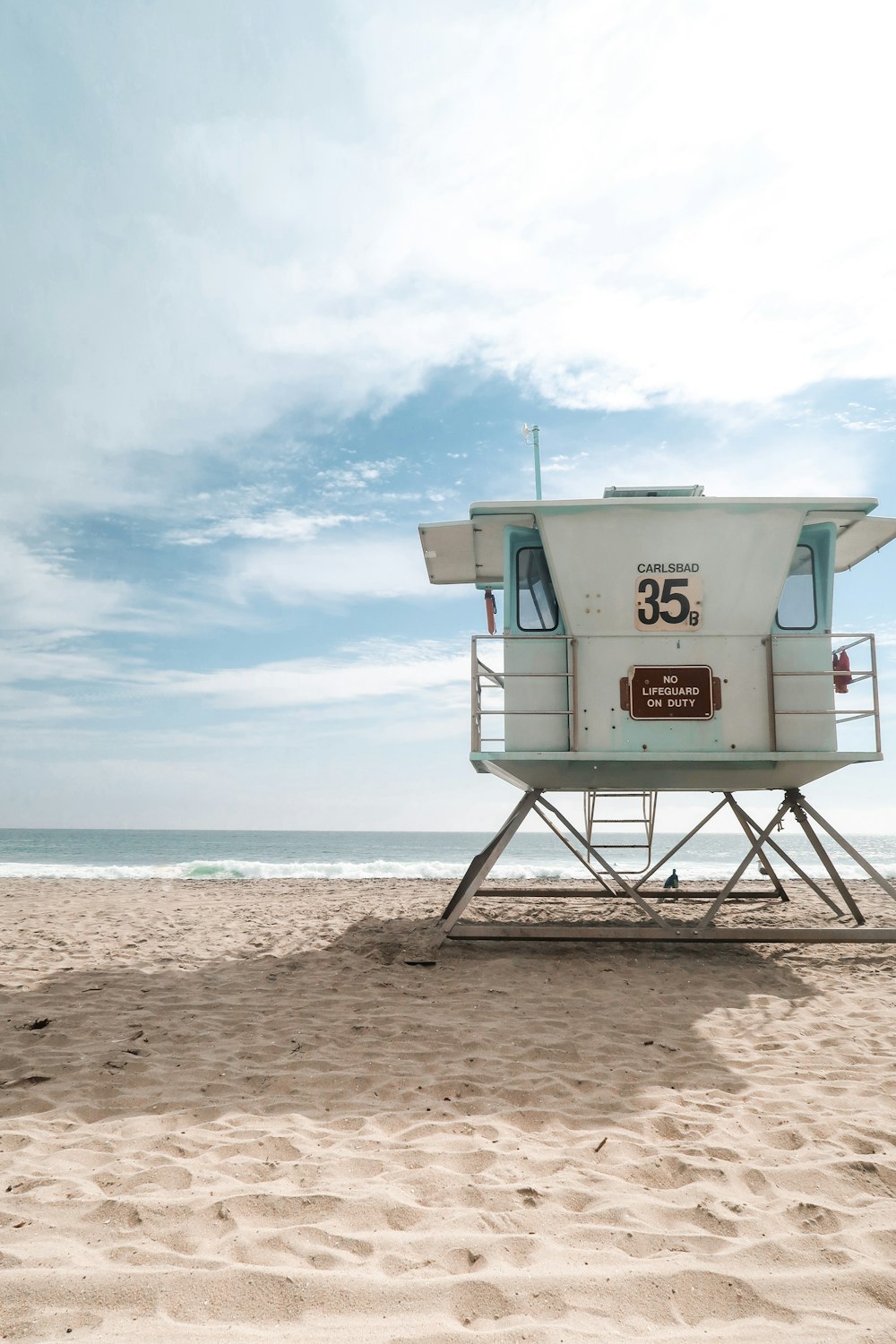 a lifeguard tower on a beach with a sky background