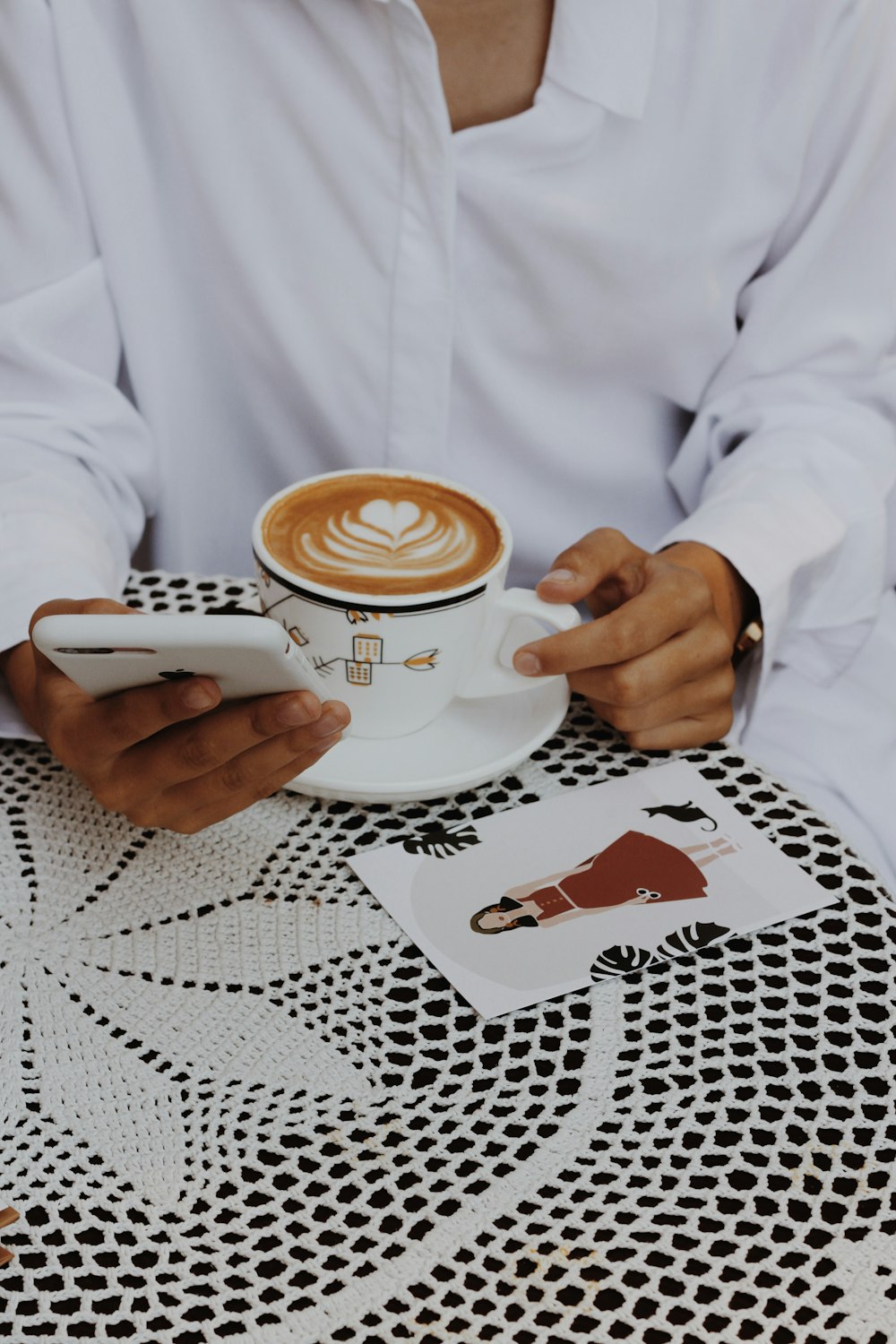 unknown person in white long-sleeved top sitting while using smartphone