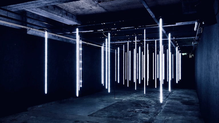 Before and after shot of a sleek industrial epoxy floor glowing under neon lights.