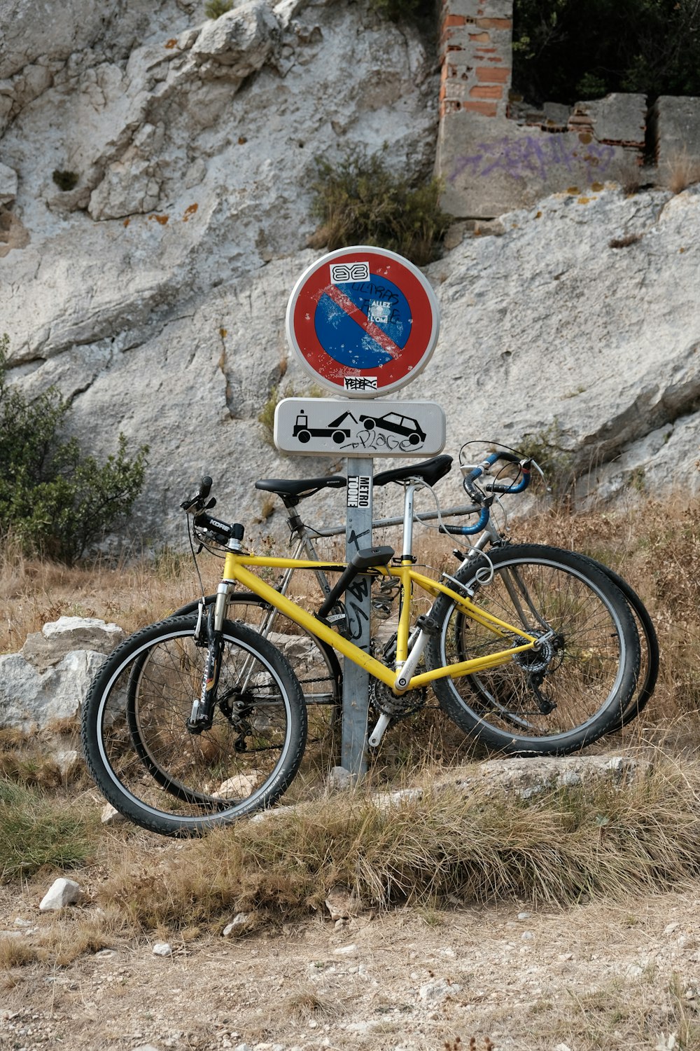 two bikes parked beside signboard on post