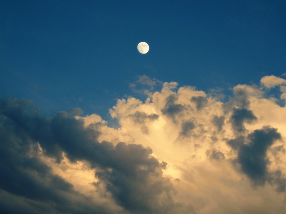 a full moon is seen through the clouds