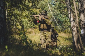 person holding rifle during daytime