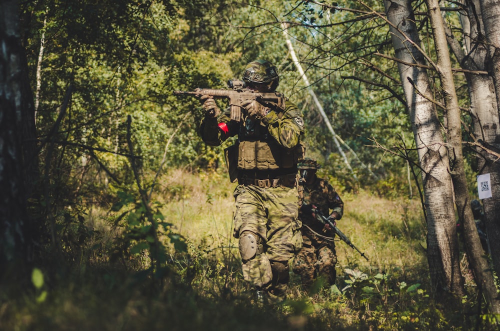 person holding rifle during daytime