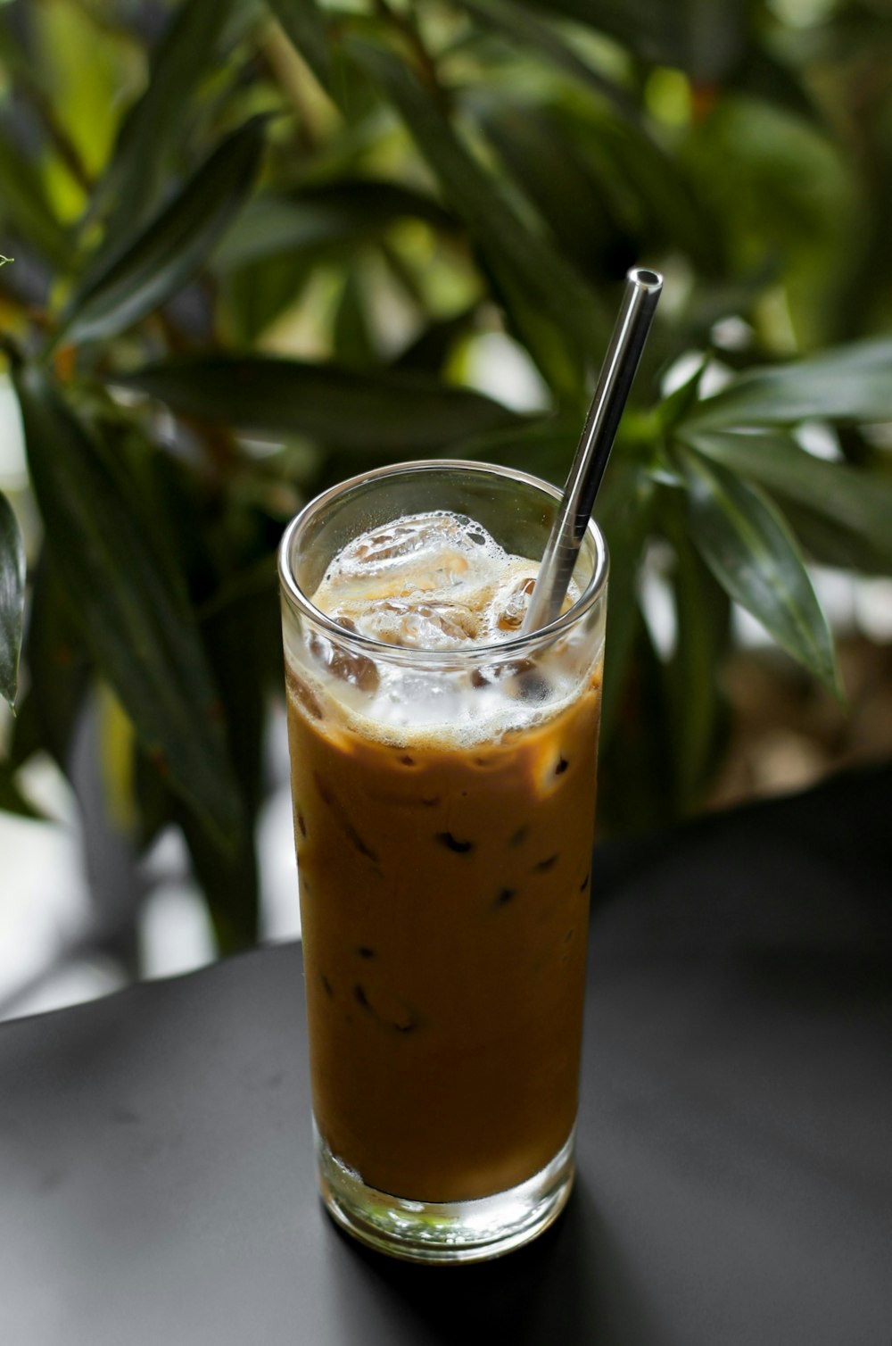 a glass of iced coffee sitting on top of a table