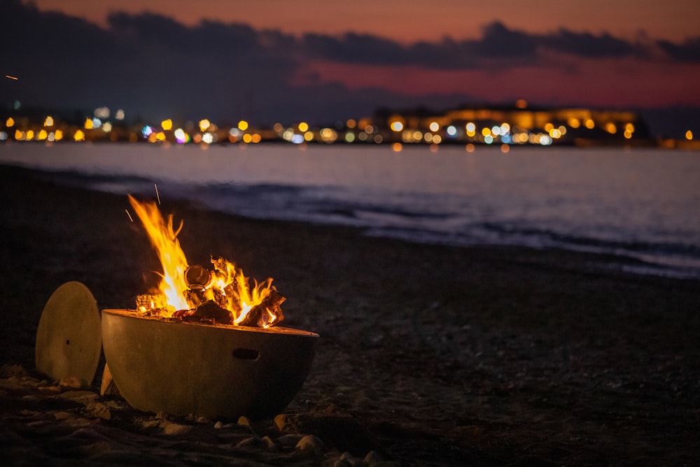 fire in fire pit on shore during golden hour