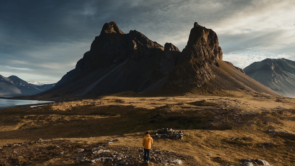 man stands near mountain