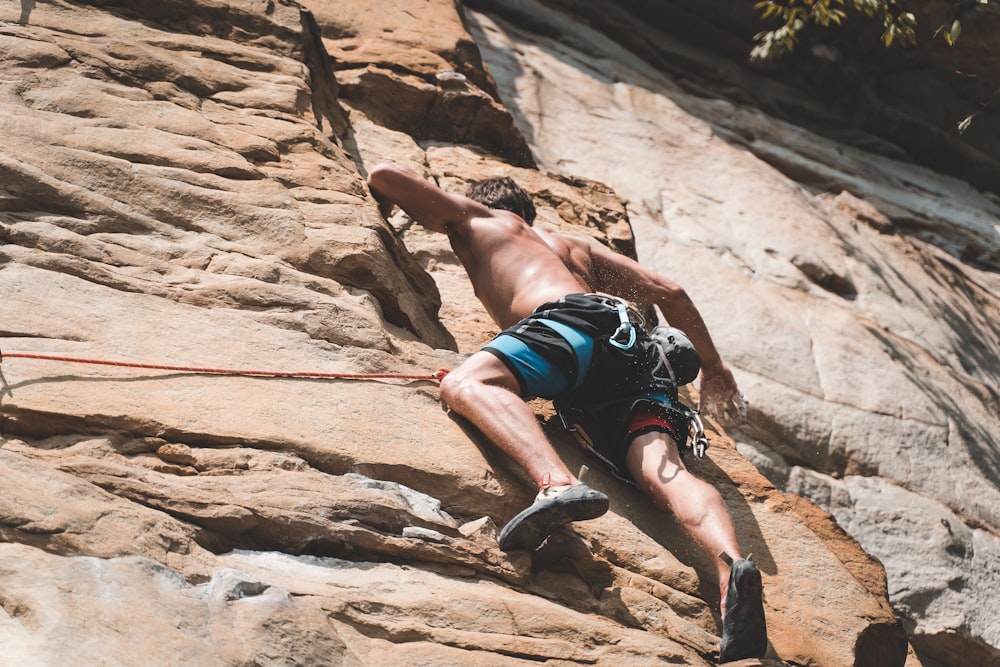 close-up photography of man climbing on mountain cliff