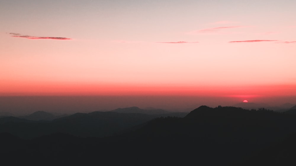 Le soleil se couche sur une chaîne de montagnes