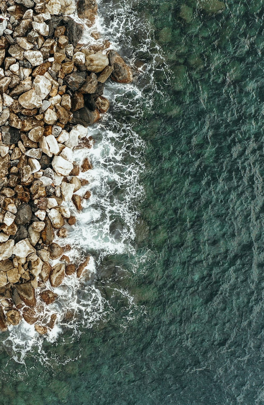 aerial photography of brown rocks near body of water during daytime