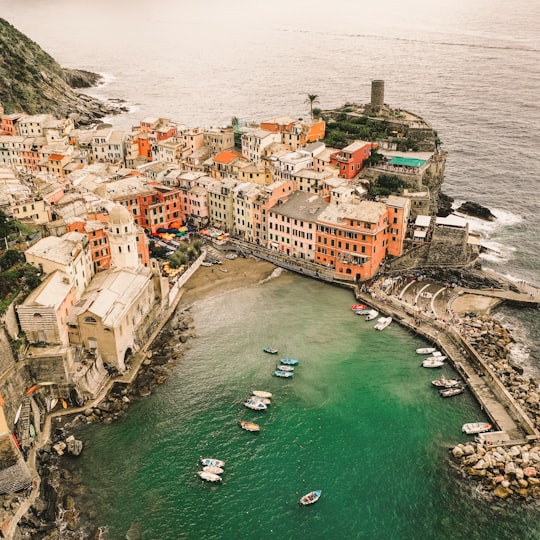 aerial view photography of cuddy boat on body of water between buildings in Parco Nazionale delle Cinque Terre Italy