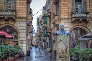 A vibrant street scene in Malta with traditional buildings and a vendor selling pastizzi, capturing the local charm.