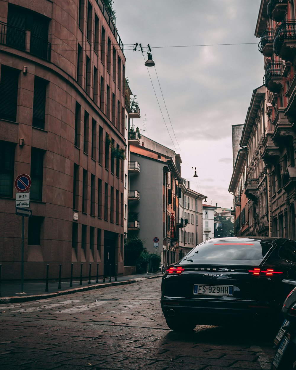 black vehicle parked beside brown building