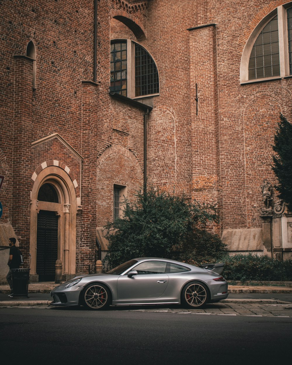 silver Porsche 911 Carrera coupe near building