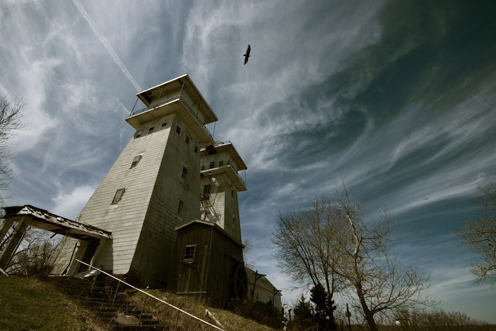 a tall tower with a bird flying over it